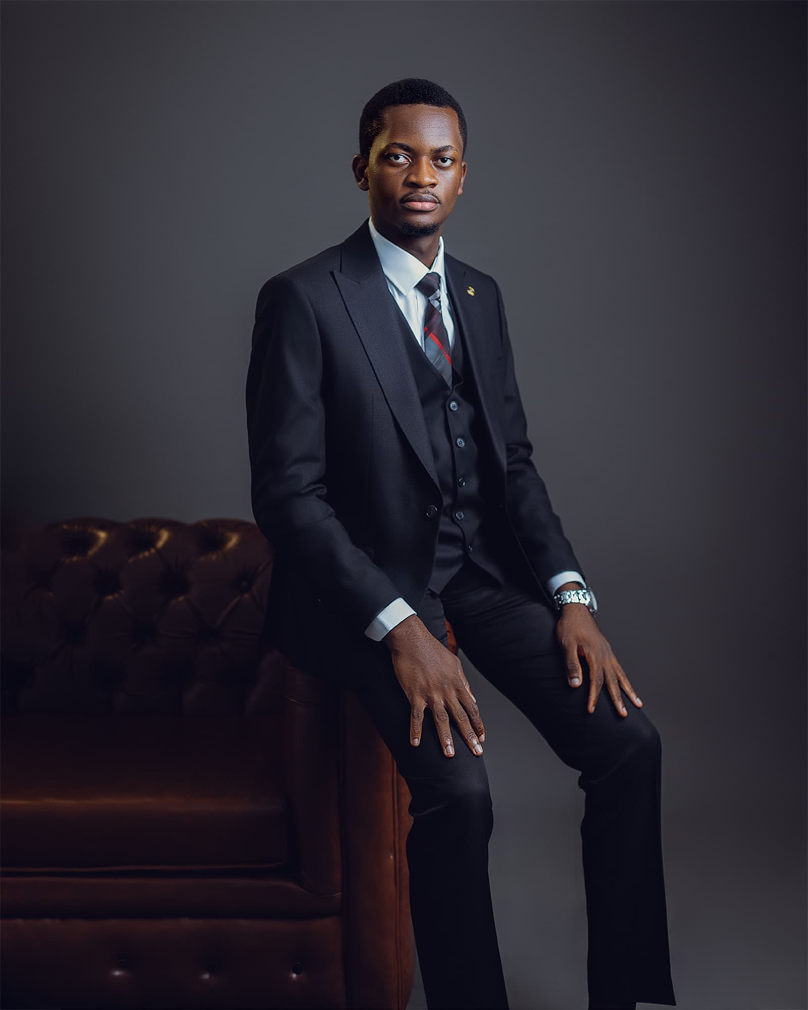 Ife Abimbola-Olulesi seated against a studio backdrop, three-quarter length